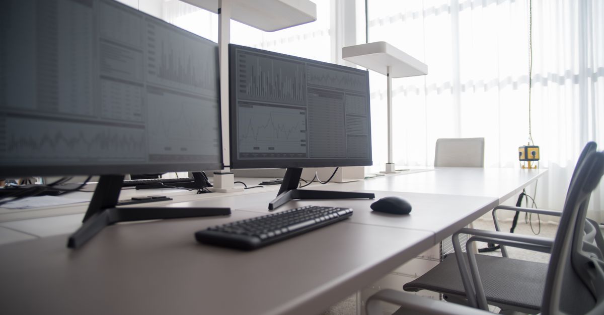 Stylish contemporary office featuring multiple computer monitors and ergonomic chairs.
